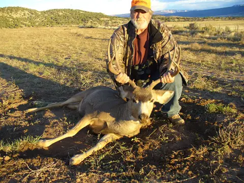 Hunter with a mule deer buck