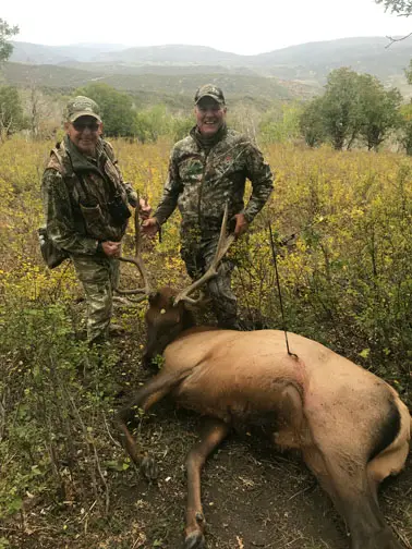 Two hunters with an elk